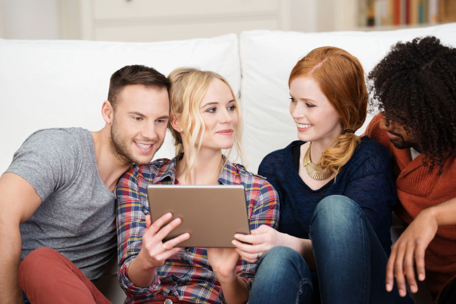 A group of authors admire the SEO author strategy looking at a tablet.